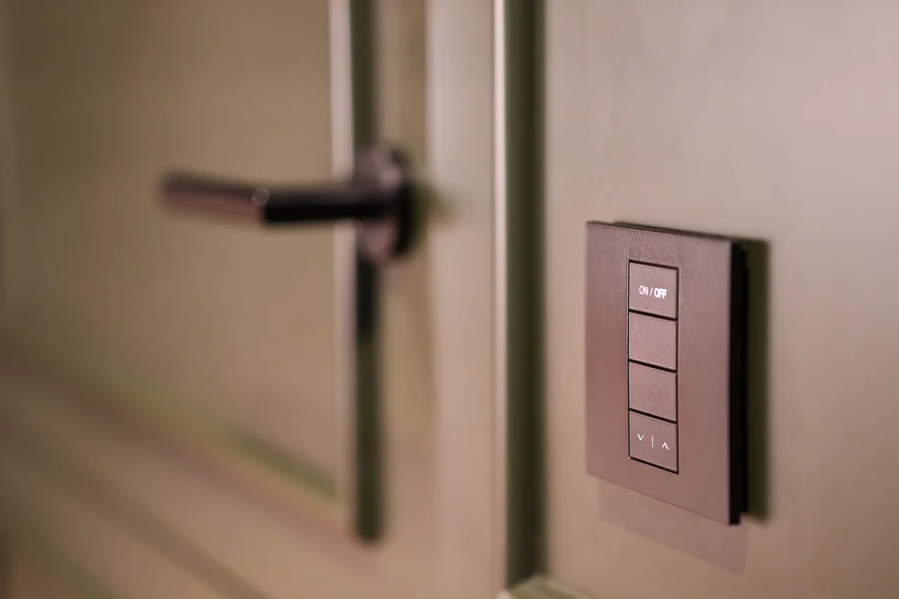 Smart lighting controls mounted beside a contemporary door handle